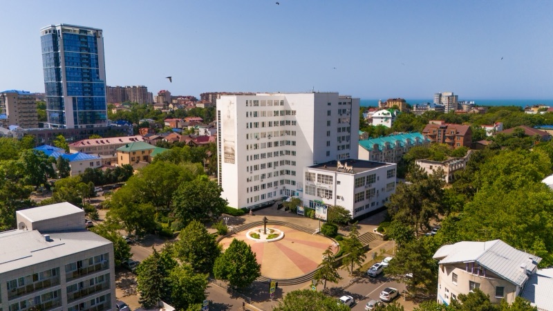 Комплекс ДиЛУЧ с высоты: главный корпус, площадь с фонтаном, зелень Анапы и море на горизонте
